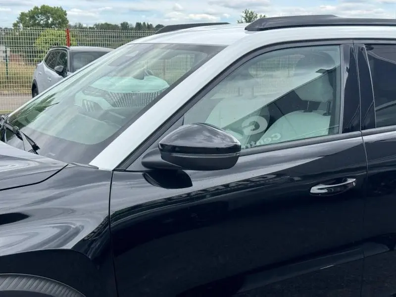 Vue latérale gauche rapprochée du Citroën C3 Aircross 2026 noir Perla Nera avec toit blanc Opale et rétroviseur noir brillant.