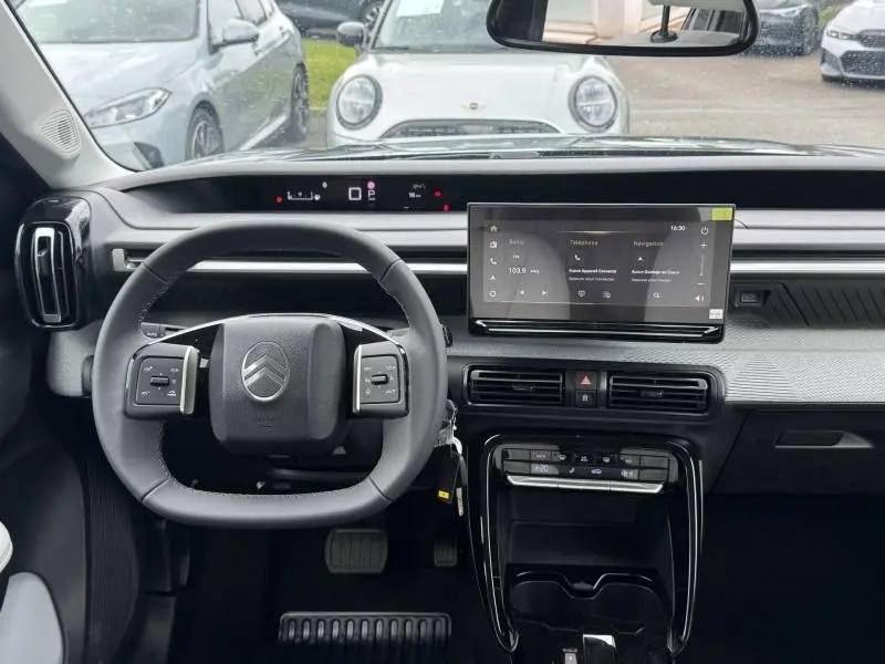 Vue intérieure frontale du tableau de bord et volant noir multifonction du Citroën C3 Aircross 2026 avec écran tactile central.