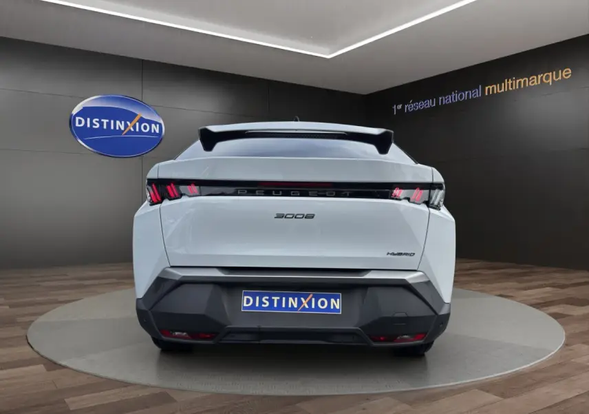 Vue arrière d'un Peugeot 3008 blanc hybride 2025 avec feux LED caractéristiques et logo distinctif au centre.
