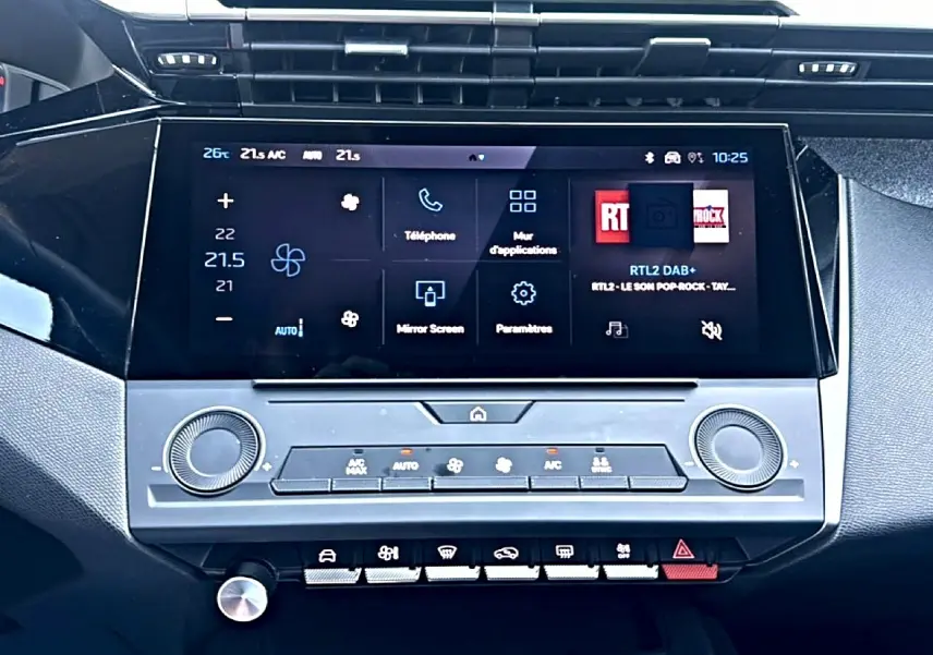 Gros plan sur l’écran tactile central et la console de la Peugeot 308 gris, affichant les commandes de climatisation et multimédia.