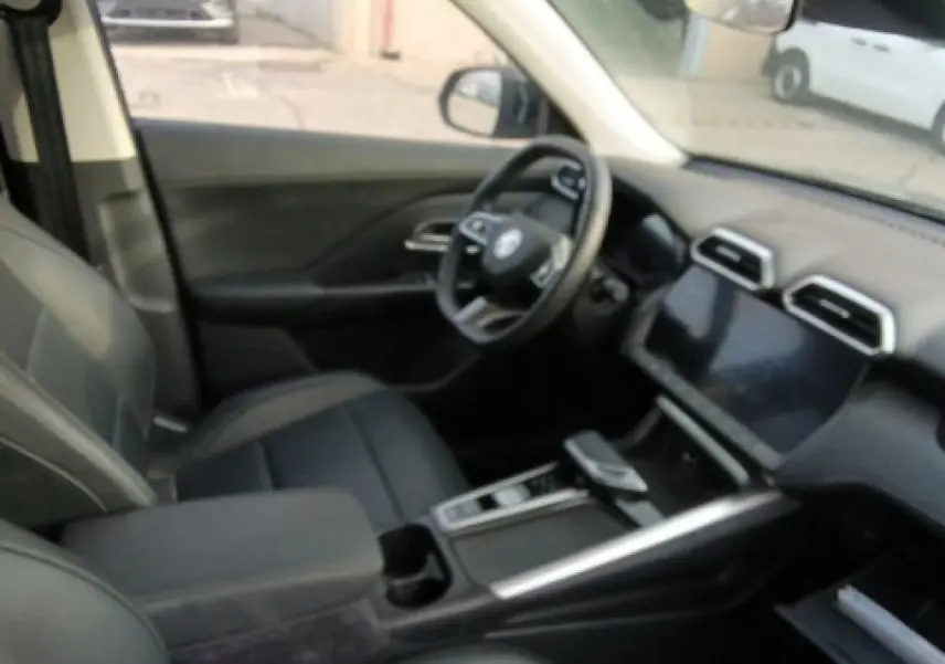 Vue intérieure côté conducteur du MG ZS 1.5 Hybrid+ 197 Luxury noir, avec volant cuir et écran tactile central.