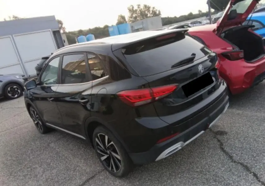 Vue 3/4 arrière droite d’un MG ZS 1.5 Hybrid+ 197 Luxury noir métallisé avec jantes alliage et vitres surteintées.