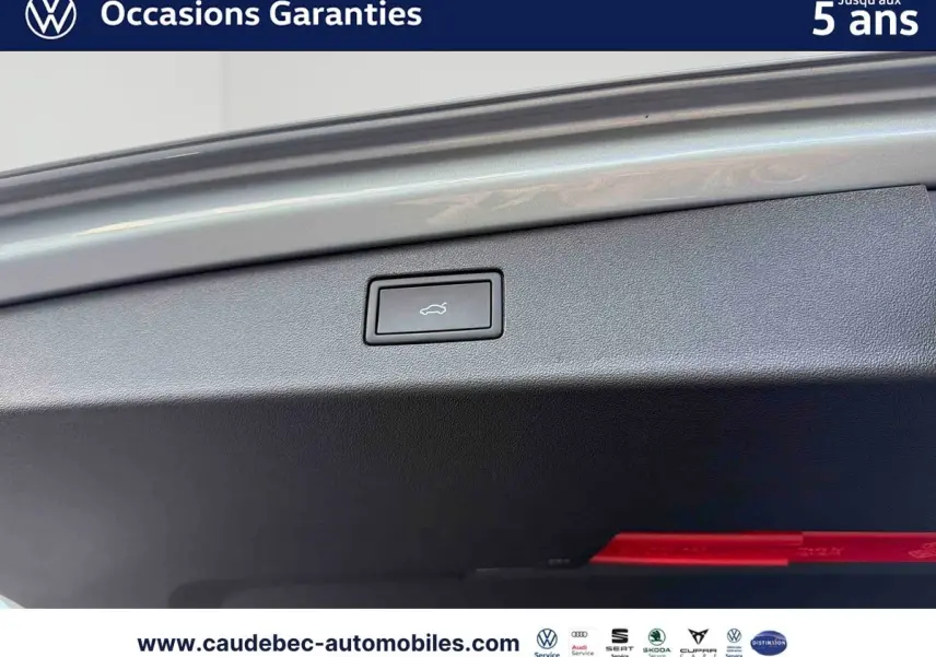 Détail du bouton d'ouverture électrique du hayon sur un Volkswagen Tiguan argent Dolomite, vue intérieure du coffre.