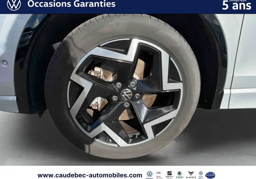 Gros plan sur la roue avant gauche du Volkswagen Tiguan 2025 argent Dolomite avec jante alliage 19 pouces bicolore.