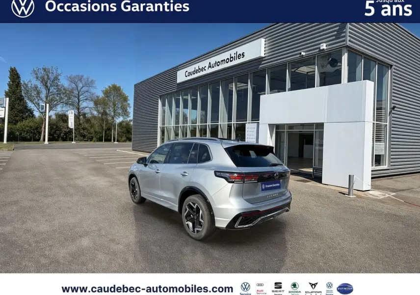 Vue 3/4 arrière droite d’un Volkswagen Tiguan 2025 argent Dolomite, avec jantes 19 pouces et toit ouvrant panoramique visible.