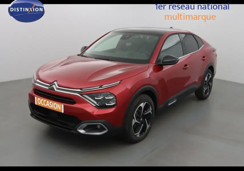 Citroën C4 X rouge Elixir métal en 3/4 avant droit, avec calandre distinctive et jantes bicolores.