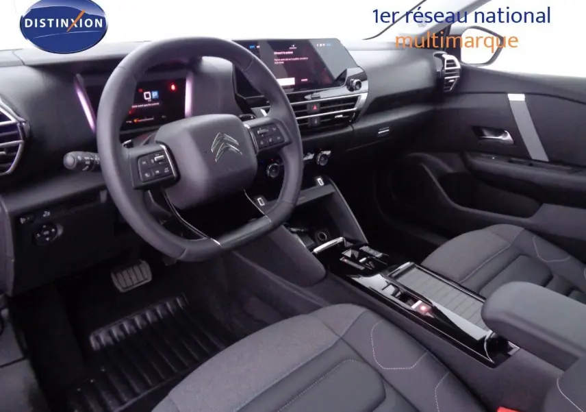 Vue intérieure du poste de conduite de la Citroën C4 X 2023, avec volant multifonction et finition noire moderne.