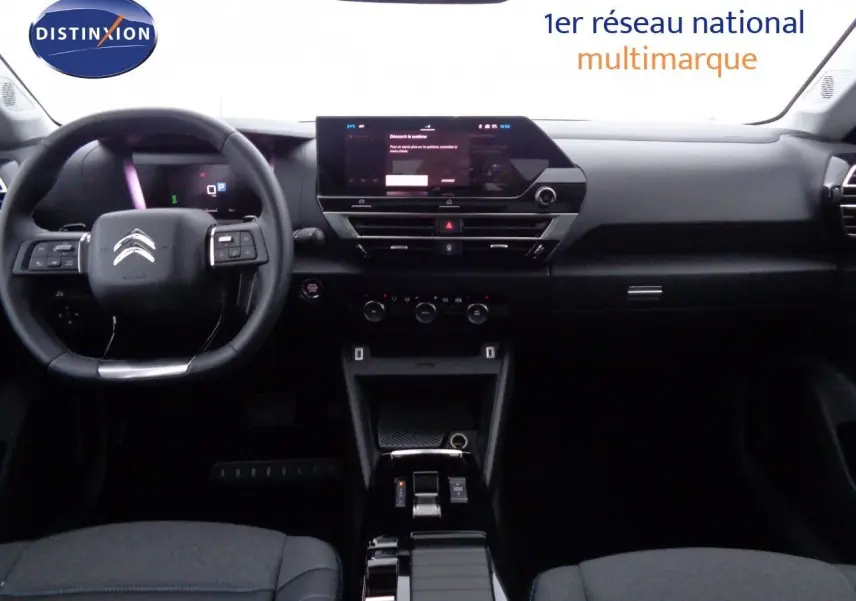 Vue intérieure frontale du tableau de bord et volant du Citroën C4 X 2023, finition noire avec écran tactile central.