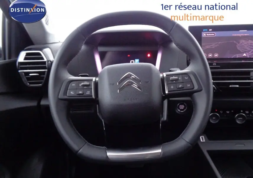 Vue rapprochée du volant noir de la Citroën C4 X 2023 avec commandes intégrées et tableau de bord digital.