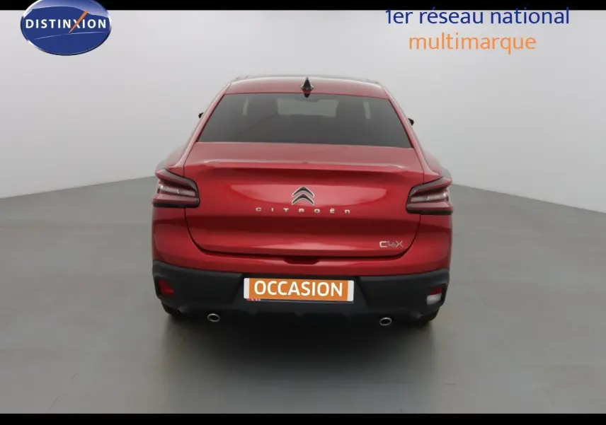 Vue arrière d'une Citroën C4 X rouge Elixir métal avec feux LED et double sortie d'échappement visible.