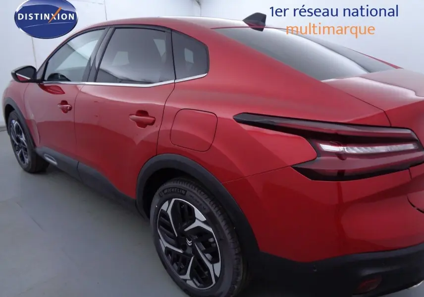 Vue 3/4 arrière droite d'une Citroën C4 X rouge Elixir Métal avec feux arrière LED et jantes bicolores.