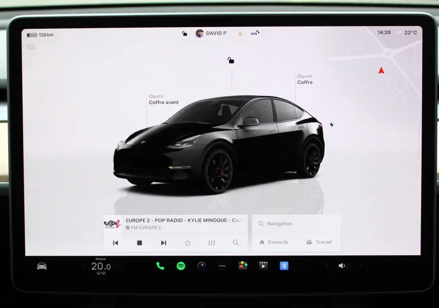 Vue 3/4 avant d'une Tesla Model Y noire métal affichée sur l'écran central tactile, avec options d'ouverture des coffres visibles.