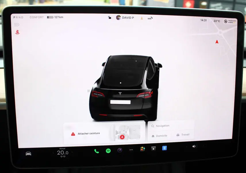 Vue arrière virtuelle du Tesla Model Y noir métal 2024 affichée sur l'écran central avec porte arrière droite ouverte.