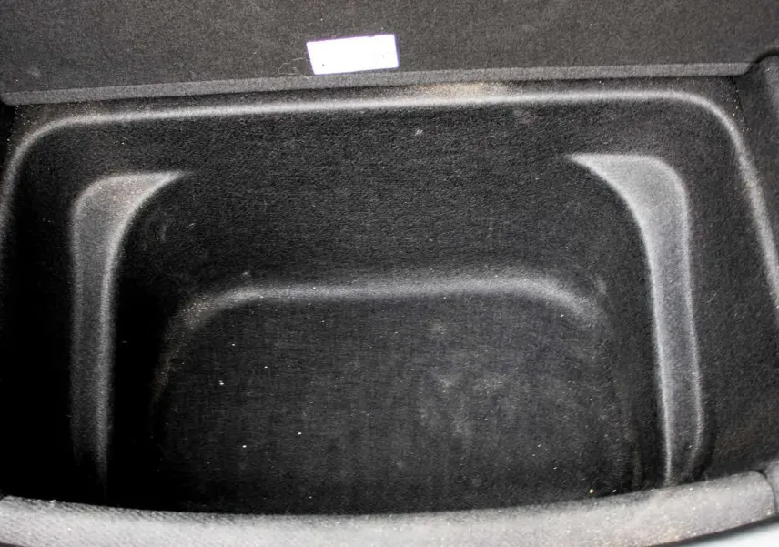 Coffre avant vide en tissu noir du Tesla Model Y Performance 2024, vue plongeante sur l'espace de rangement électrique.