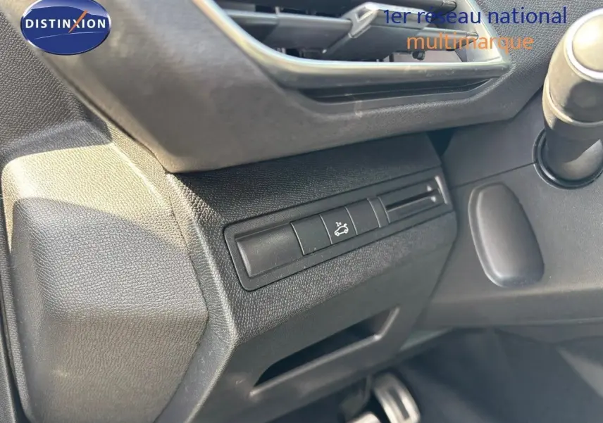 Détail du tableau de bord côté gauche du Peugeot 3008 GT blanc nacré, avec bouton d'ouverture du capot visible.