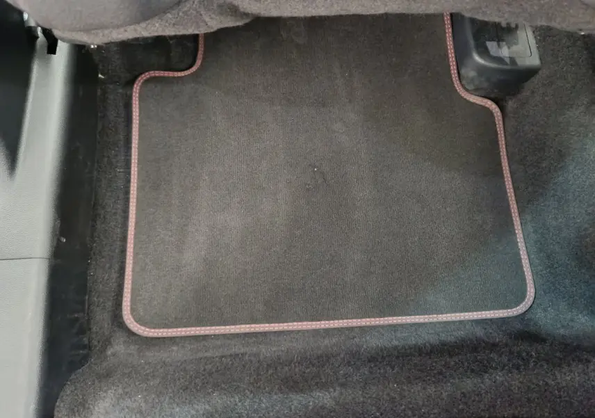 Tapis de sol noir avec surpiqûres rouges dans l'habitacle du Ford Kuga 2024 version St Line.
