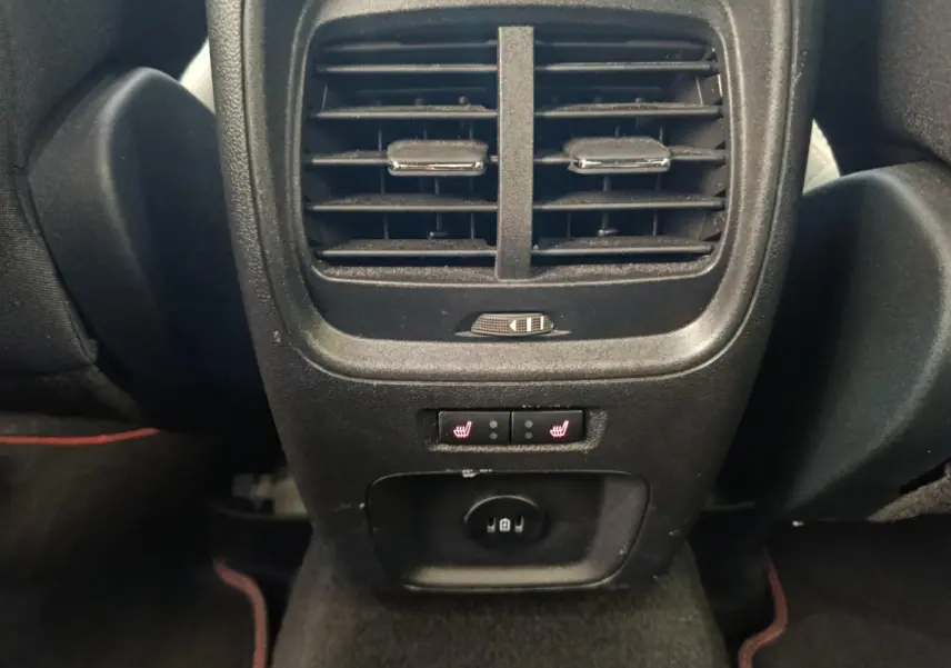 Vue rapprochée de la console arrière noire du Ford Kuga 2024 avec aérateurs et commandes chauffantes des sièges arrière.