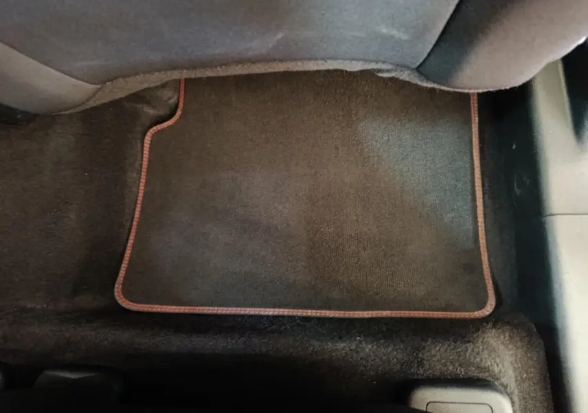 Tapis de sol noir avec surpiqûres rouges dans l'habitacle arrière du Ford Kuga 2024 St Line bleu.