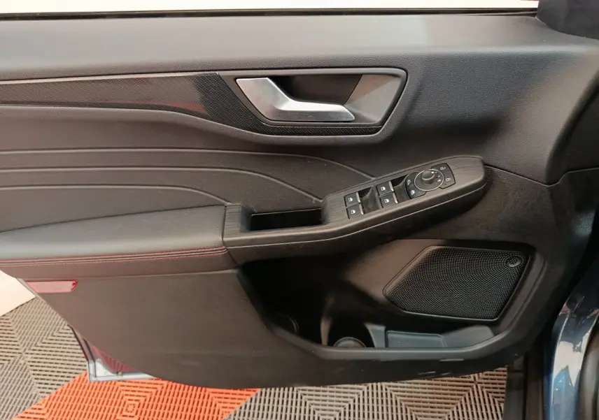 Vue rapprochée de la porte côté gauche du Ford Kuga bleu 2024, avec commandes électriques et garniture noire.