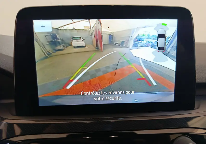 Écran tactile intérieur montrant la caméra de recul avec guidage et vue 360° du Ford Kuga bleu 2024.