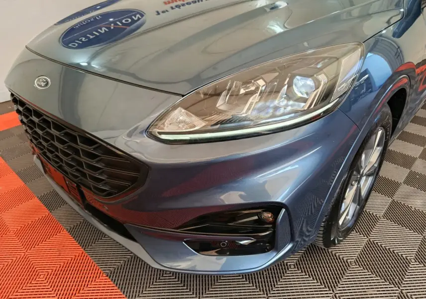 Vue en 3/4 avant droit d'un Ford Kuga bleu 2024 avec calandre noire et phares LED distinctifs.