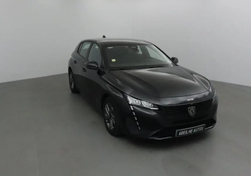 Peugeot 308 noire vue en 3/4 avant droit, mettant en valeur sa calandre moderne et ses phares LED distinctifs.