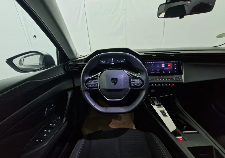 Écran tactile central de la Peugeot 308 noire 2022 affichant le menu navigation et paramètres, avec commandes climatisation.