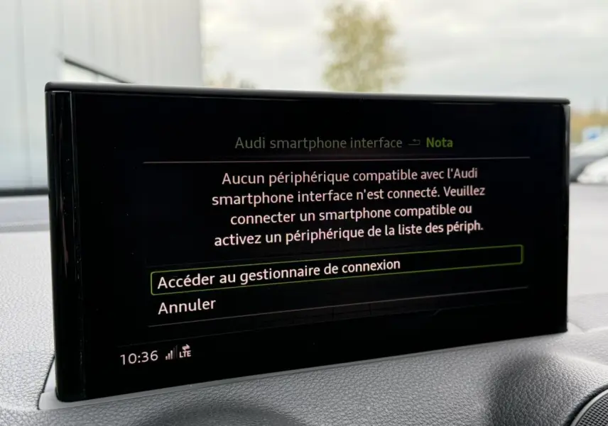 Écran central de l'Audi Q2 35 TFSI S-Line 2023 affichant le message de connexion smartphone, intérieur gris.