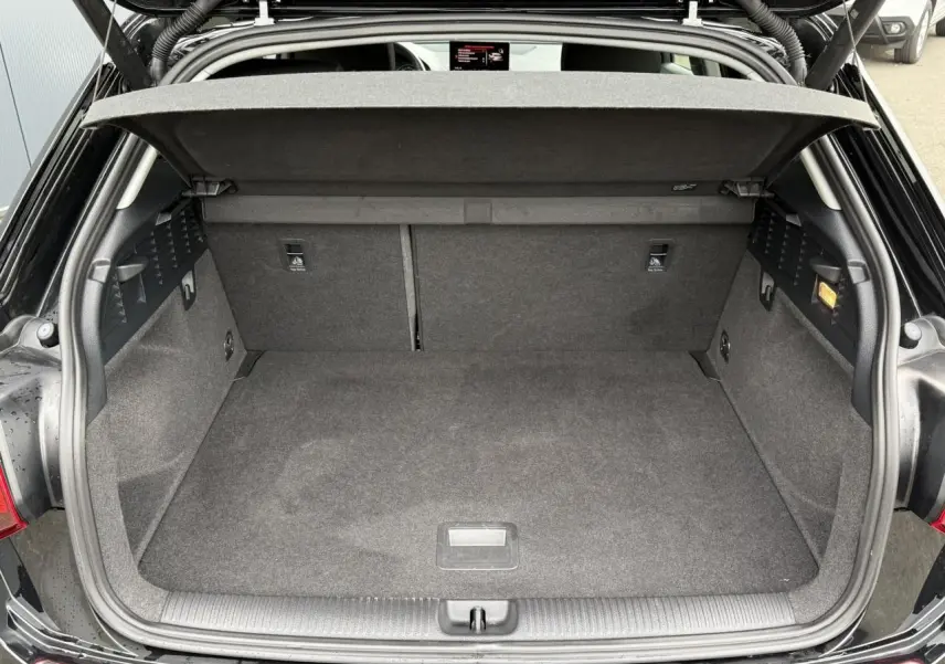 Coffre ouvert vu de l'arrière d'un Audi Q2 35 TFSI S-Line noir Mythe avec hayon électrique et plancher plat.