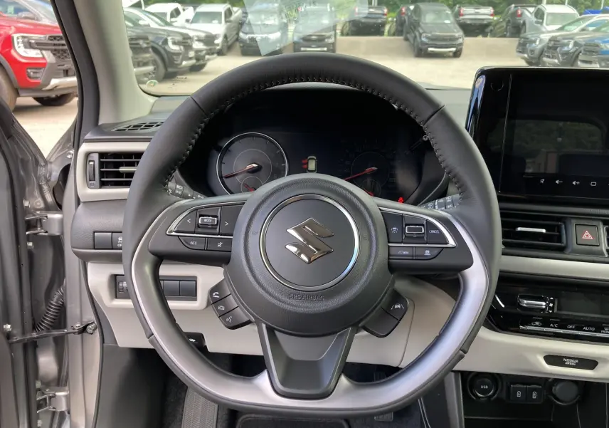 Vue intérieure centrée sur le volant cuir multifonctions de la Suzuki Swift 2025 en Premium Silver Metal.