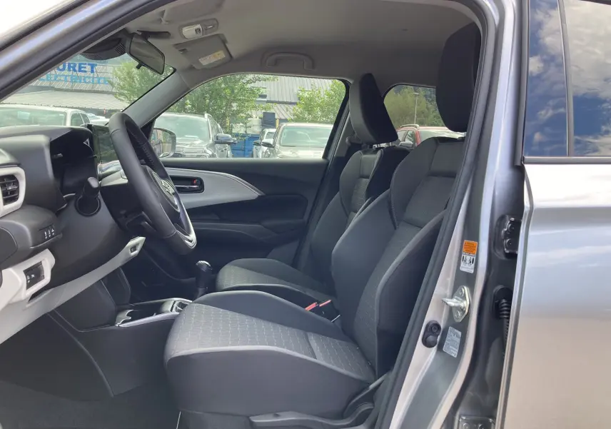 Vue intérieure côté conducteur de la Suzuki Swift 2025 Premium Silver avec sièges tissu et volant cuir multifonctions.