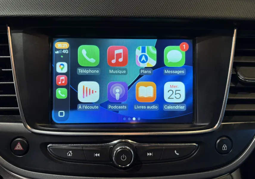 Écran tactile central de l’Opel Crossland rouge 2022 affichant l’interface Apple CarPlay avec plusieurs applications.