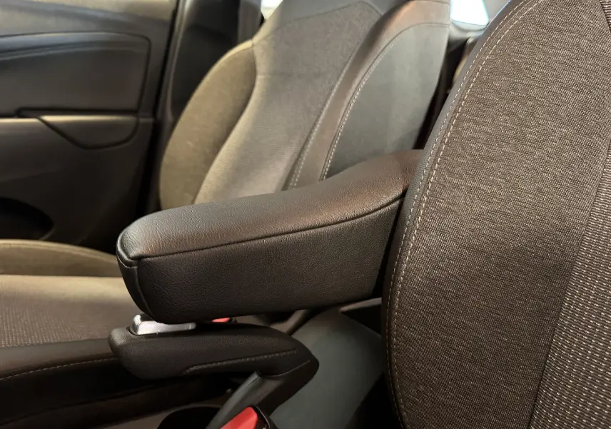 Accoudoir central en cuir noir entre les sièges avant gris foncé de l’Opel Crossland rouge, vue intérieure côté droit.