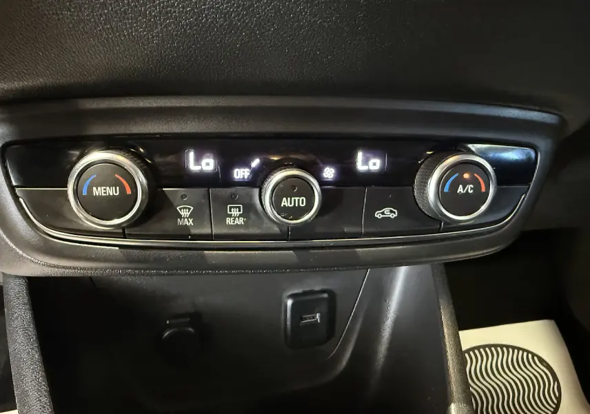 Gros plan sur la commande de climatisation automatique de l’Opel Crossland rouge, avec réglages température affichés "Lo".