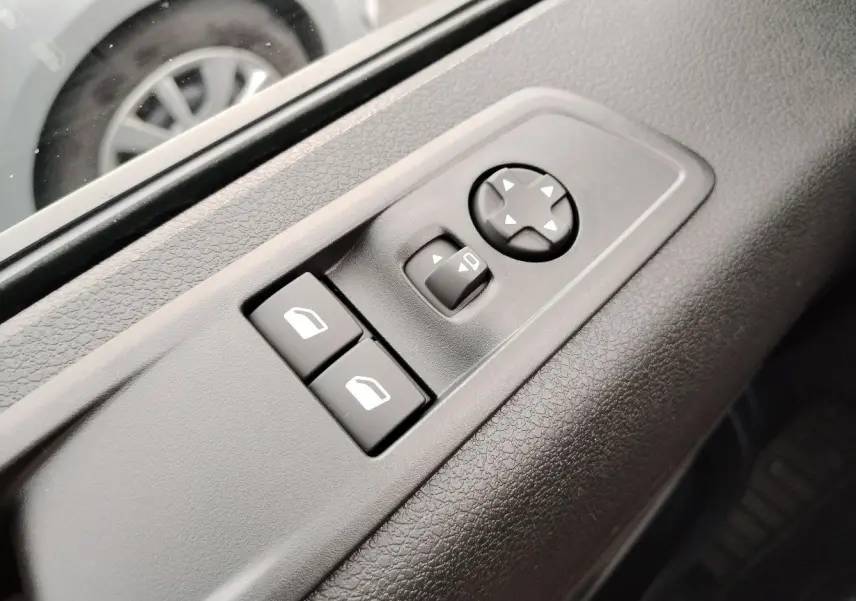 Gros plan sur les commandes de réglage des rétroviseurs et vitres côté conducteur du Fiat Ulysse noir Perla 2026.