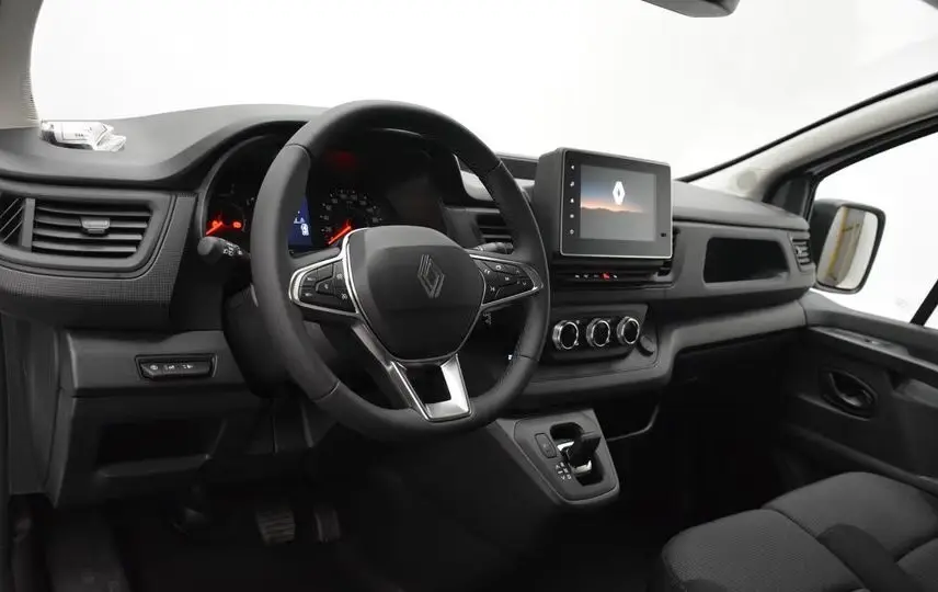 Vue intérieure côté conducteur du Renault Trafic Fourgon blanc 2025, volant multifonction et écran tactile central.