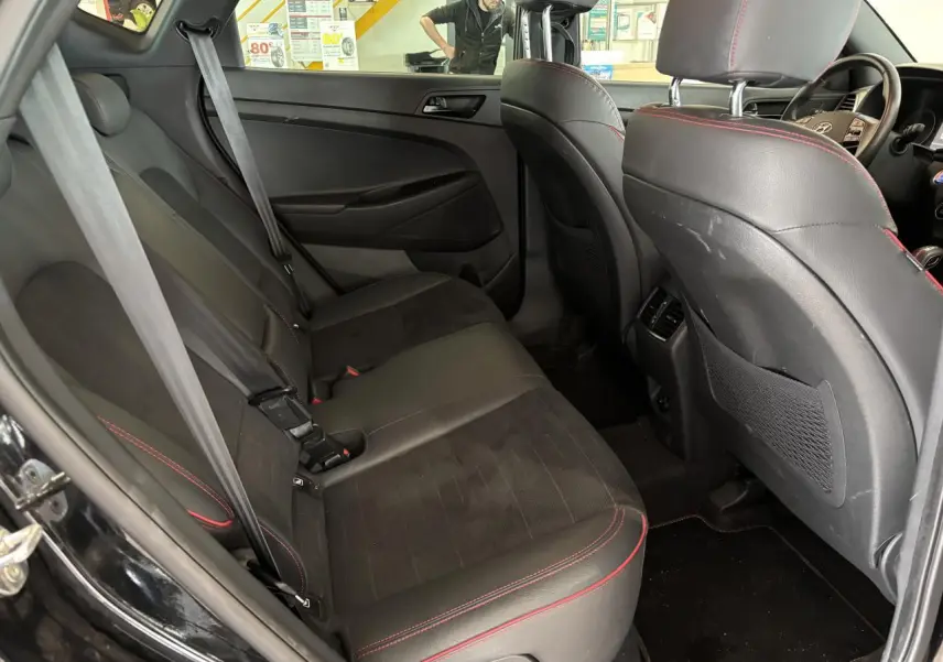 Vue intérieure côté gauche des sièges arrière noirs avec surpiqûres rouges du Hyundai Tucson N Line Edition 2020.