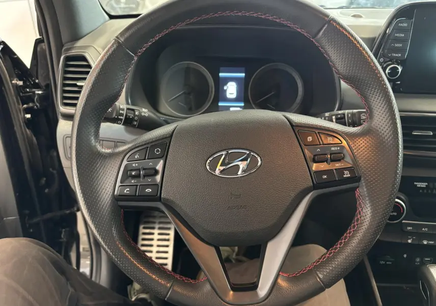 Vue intérieure centrée sur le volant cuir noir avec surpiqûres rouges du Hyundai Tucson N Line 2020.