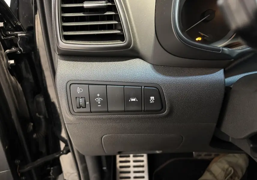 Vue intérieure côté gauche du tableau de bord noir du Hyundai Tucson 2020 avec commandes d'assistance et pédalier aluminium.