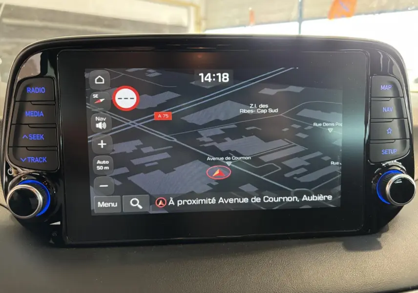 Écran tactile central du Hyundai Tucson 2020 affichant la navigation, boutons latéraux rétroéclairés en bleu.