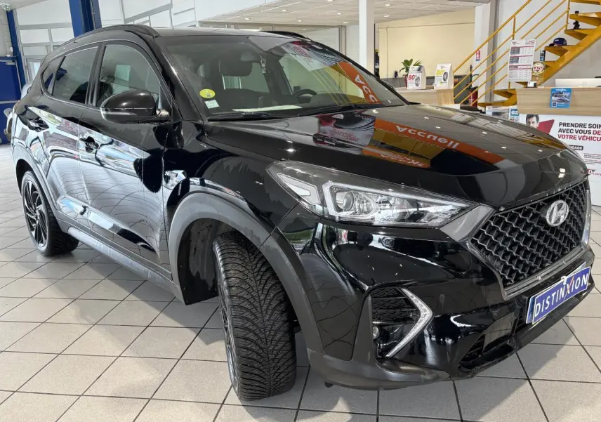 Hyundai Tucson noir en 3/4 avant droit, avec calandre N Line et jantes alliage noires 19 pouces.