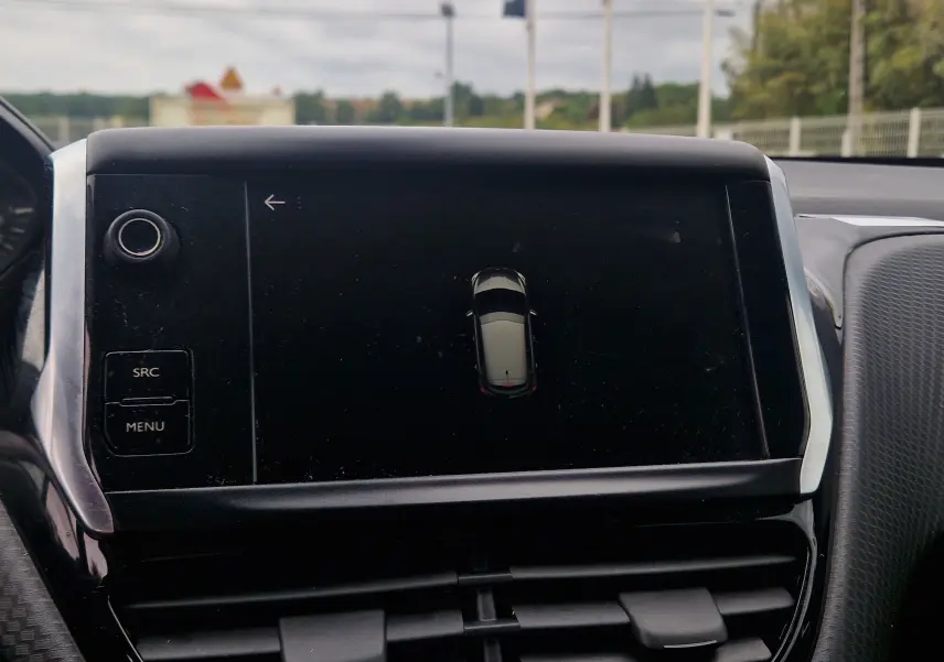 Écran tactile central de la Peugeot 208 blanc nacré 2018 affichant la vue aérienne du véhicule en stationnement.