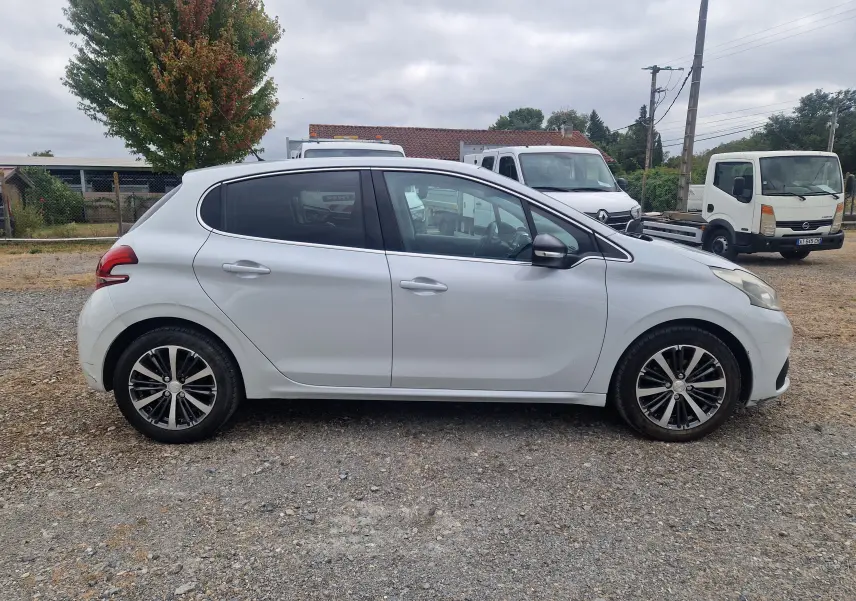 Peugeot 208 blanc nacré vue de profil côté gauche, avec jantes alliage bicolores et poignées de porte assorties.