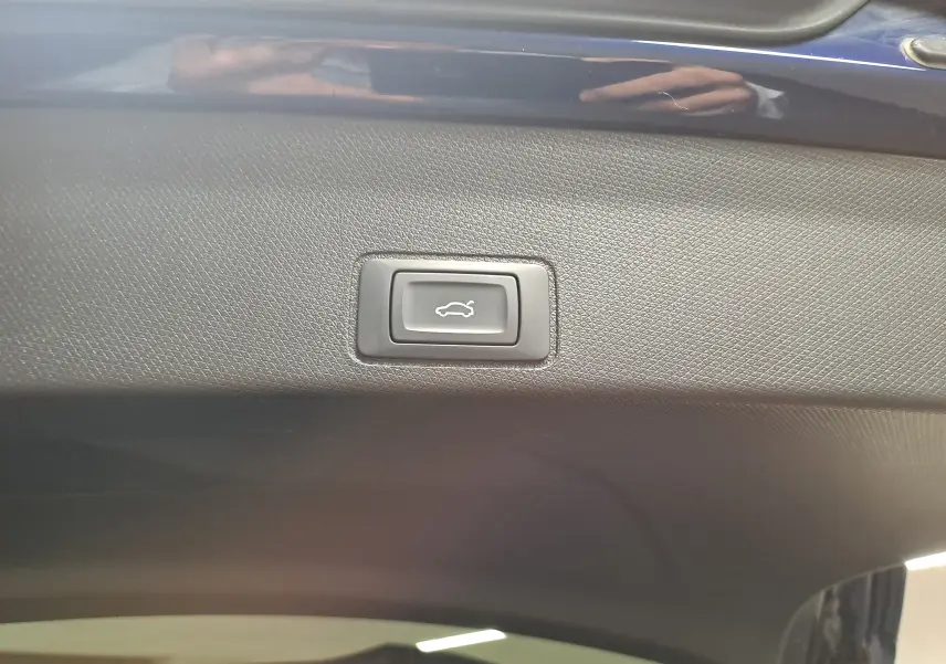 Bouton d'ouverture électrique du coffre sur la partie intérieure du hayon d'une CUPRA TERRAMAR bleu cosmos.