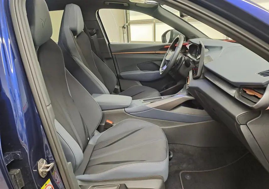 Vue intérieure côté conducteur de la CUPRA TERRAMAR bleu cosmos 2025 avec sièges sport et tableau de bord moderne.