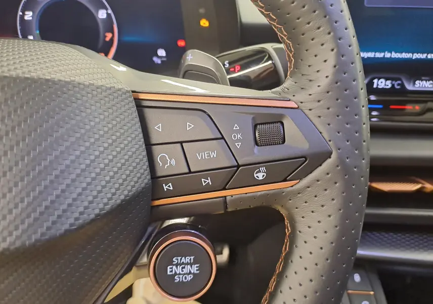 Gros plan sur le volant en cuir perforé avec commandes multifonctions et bouton Start Engine Stop du CUPRA Terramar 2025.
