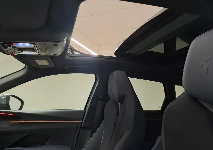 Vue intérieure côté gauche du CUPRA TERRAMAR 2025 avec toit ouvrant panoramique et sièges noirs au logo embossé.