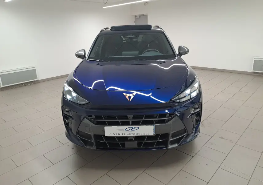 Vue avant d'une CUPRA TERRAMAR 1.5 eHybrid bleu cosmos avec toit ouvrant panoramique en intérieur showroom.