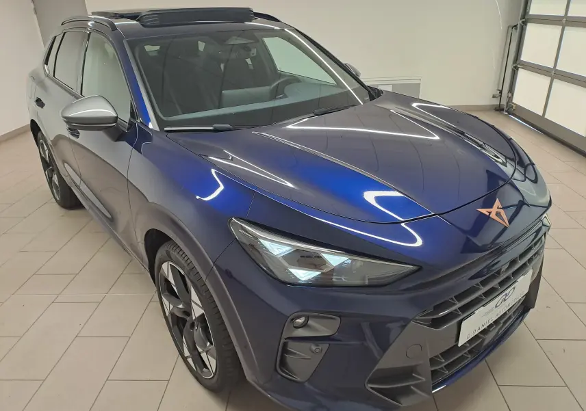Vue 3/4 avant du CUPRA TERRAMAR bleu cosmos avec jantes 20'' Gravity et toit ouvrant panoramique en intérieur.