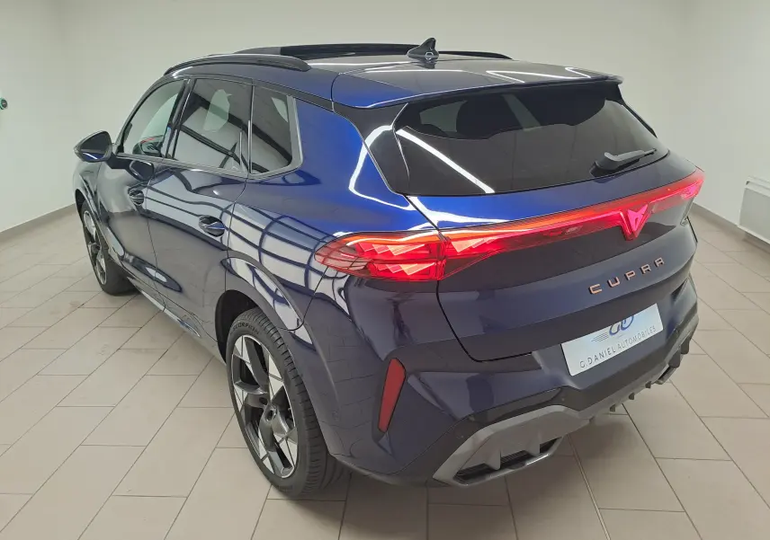 Vue 3/4 arrière droite du CUPRA TERRAMAR bleu cosmos avec feux arrière allumés et jantes 20'' Gravity usinées.